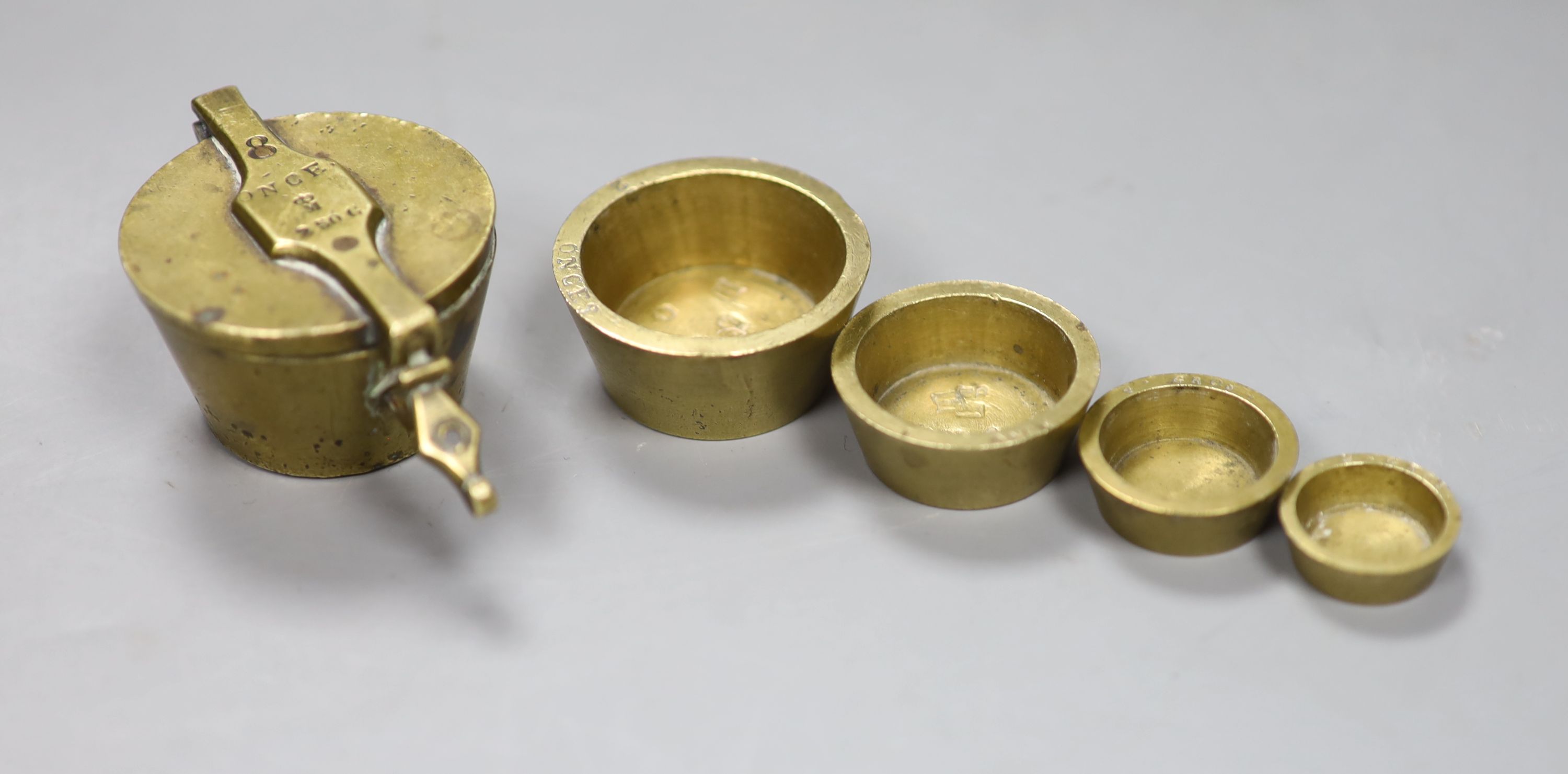 A Victorian brass 8 ounce cup weights